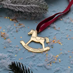 Adorno colgante de árbol de navidad de caballo balancín de acrílico dorado con cinta roja.