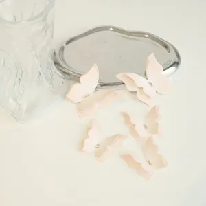 Vue détaillée de toppers gâteau papillon rose avec strass, parfaits pour table de fête.