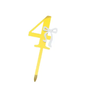 Gold acrylic number 4 cake topper with white bow, perfect for birthday party decorations.