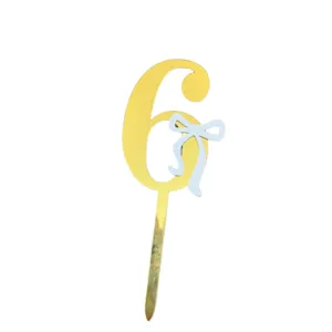 Gold number six acrylic cake topper with light blue bow detail close up shot for birthday party