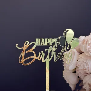 Primer plano de cake topper feliz cumpleaños de acrílico dorado con globos y decoración floral