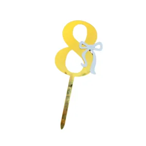 Gold acrylic number 8 cake topper with blue bow for birthday party cake decoration details.