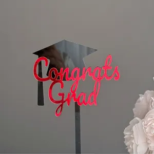 Graduation cake topper detail shot showing the glossy red acrylic Congrats Grad lettering.