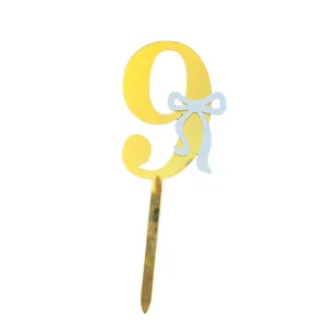 Gold acrylic number 9 cake topper with light blue bow detail for birthday party decoration