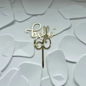 Gold acrylic Hello 60 cake topper detail, elegant metallic shine birthday party dessert decor.