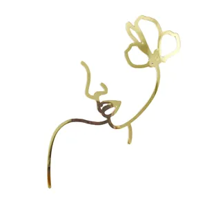 Gold acrylic abstract face cake topper, elegant line art dessert decoration for parties.