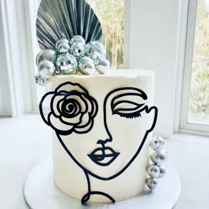 INS style abstract face cake topper set with silver disco balls and palm leaf decoration for party.