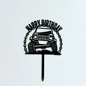 Detalle de cake topper de coche todoterreno acrílico negro con texto de cumpleaños.