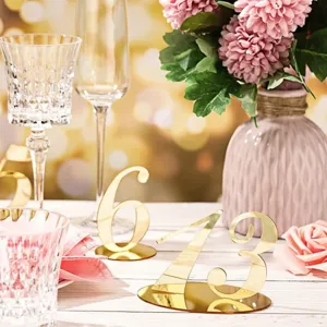 Vista detallada de números de mesa de acrílico dorado, ideales para bodas y fiestas.