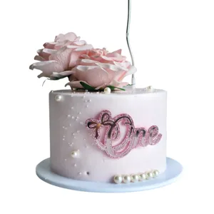 Pink acrylic One cake topper with artificial roses and pearls for first birthday party decor detail