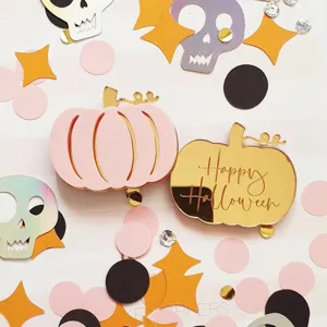 Detailed close-up of acrylic Halloween pumpkin brooches with cute pastel colors and gold mirror.