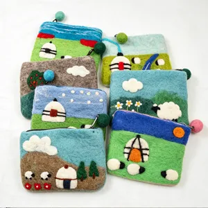 Handmade wool felt coin purse detail showing cute sheep and landscape design with zipper.
