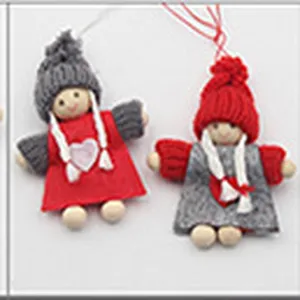 Close-up detail of cute knitted Christmas hanging dolls with red and gray hats and heart decor.
