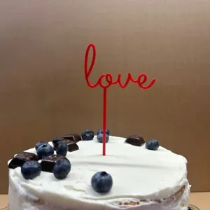 Red acrylic LOVE cake topper detail shot for wonderful dessert table decoration.