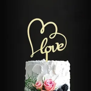 Details of the gold acrylic LOVE heart cake topper for romantic dessert table decoration.
