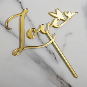 Gold acrylic love cake topper detail, elegant heart design for wedding and party dessert decor.