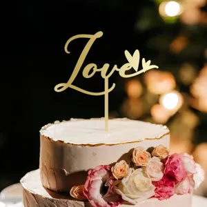 Gold acrylic LOVE cake topper detail shot, elegant wedding party dessert decoration.
