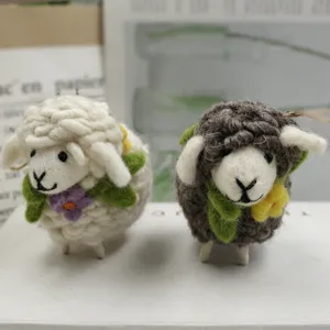 Detalle primer plano muñeca oveja de fieltro de lana hecha a mano, colgante de animal, suave.