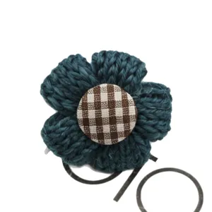 Handmade crochet flower hair tie with gingham button center, cute dark blue hair accessory.
