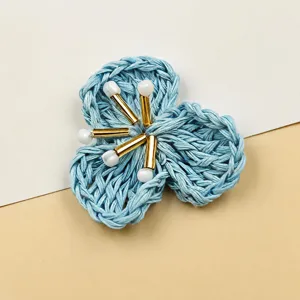 Blue woven straw flower detail shot, handmade floral DIY accessory with pearl beads center view.