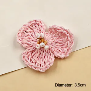 Detailed close-up of a handmade crochet 3-petal pink flower DIY accessory with pearl center.