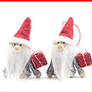 Christmas gnome plush toy detail, cute holiday decoration figure with red hat and gift box.