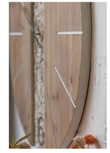 Nahaufnahme der großen Holz-Wanduhr zeigt natürliche Holzmaserung und geschnitzte Muster.