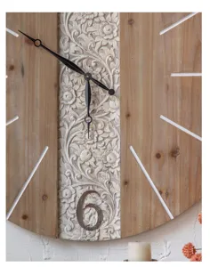 Detailaufnahme einer großen rustikalen Holz-Wanduhr mit handgeschnitztem Blumenmuster.