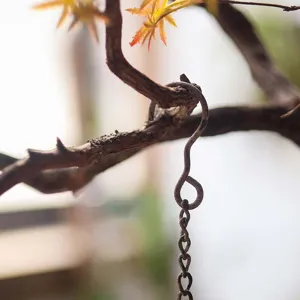 Vintage industrial metal S-hook and hanging chain for outdoor garden bird feeder decor.