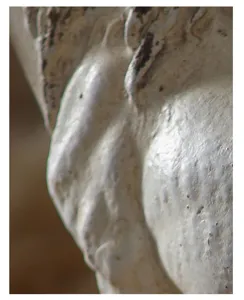 Close-up detail of wabi-sabi resin ornament showing unique distressed white surface texture.