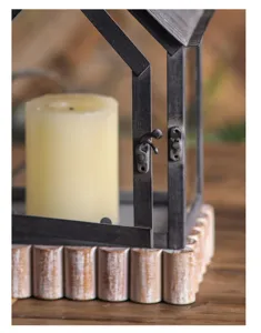 Close-up detail of retro iron glass house candle lantern with pillar candle for home decor.