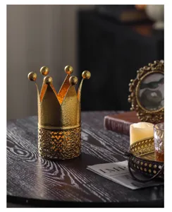 Detailed view of European classical gold crown candle holder, vintage metal desktop decor piece.