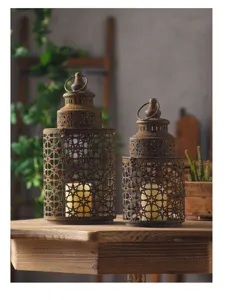Rustic distressed iron candle lantern detail shot showcasing hollowed star pattern and vintage metal texture.