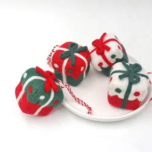 Gros plan de charmants ornements de boîte cadeau de Noël en feutre pour décoration d'arbre.
