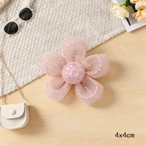 Handmade pink sequin mesh five-petal flower detail view, craft accessory, delicate texture.