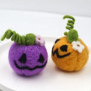 Handcrafted wool felt pumpkin detail featuring cute spooky faces and green curly stems.