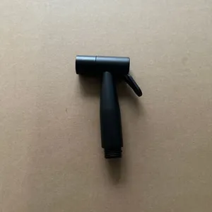 Black plastic bidet sprayer nozzle detail shot for efficient toilet cleaning and hygiene
