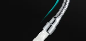 Stainless steel faucet extender detail view showing flexible hose and smooth water flow.