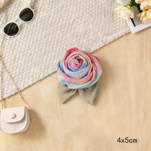 Detailed shot of fabric mesh rose flower accessory with gradient colors and leaves, exquisite design.