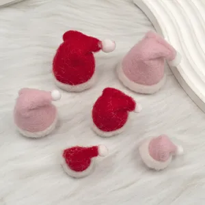 Wool felt Christmas hat detail shot, pink and red miniature DIY holiday craft decoration accessories.