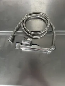 Dettaglio del set doccetta bidet con flessibile e supporto per la pulizia del bagno.