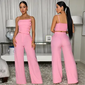 Pink two-piece set featuring a pleated camisole with metal buttons and matching wide leg pants.