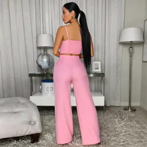 Stunning pink two-piece set featuring a cropped strap top and matching wide-leg trousers.