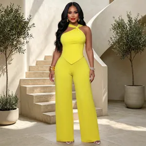 Detail shot of stylish yellow halter twisted top and wide leg pants set in luxury interior.