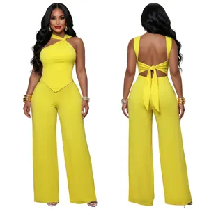 Yellow halter neck jumpsuit featuring a chic twist front, open back tie detail, and wide legs.