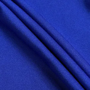 Royal blue ribbed fabric detail view displaying fine knit texture and soft cloth textile folds.