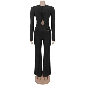 Black ribbed long-sleeve jumpsuit close-up featuring chic waist cutout and gold hardware.