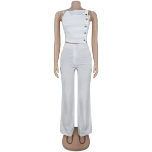 Close-up details of white pleated camisole and wide leg pants set with metal buttons.