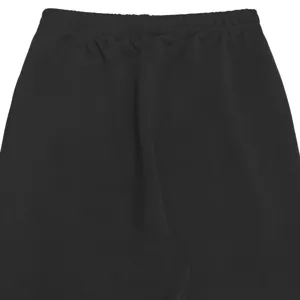 Detail shot of black women's trousers waist showing elastic waistband and fine fabric texture.