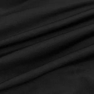 Black dress fabric detail close up showing smooth texture and elastic material weave quality.
